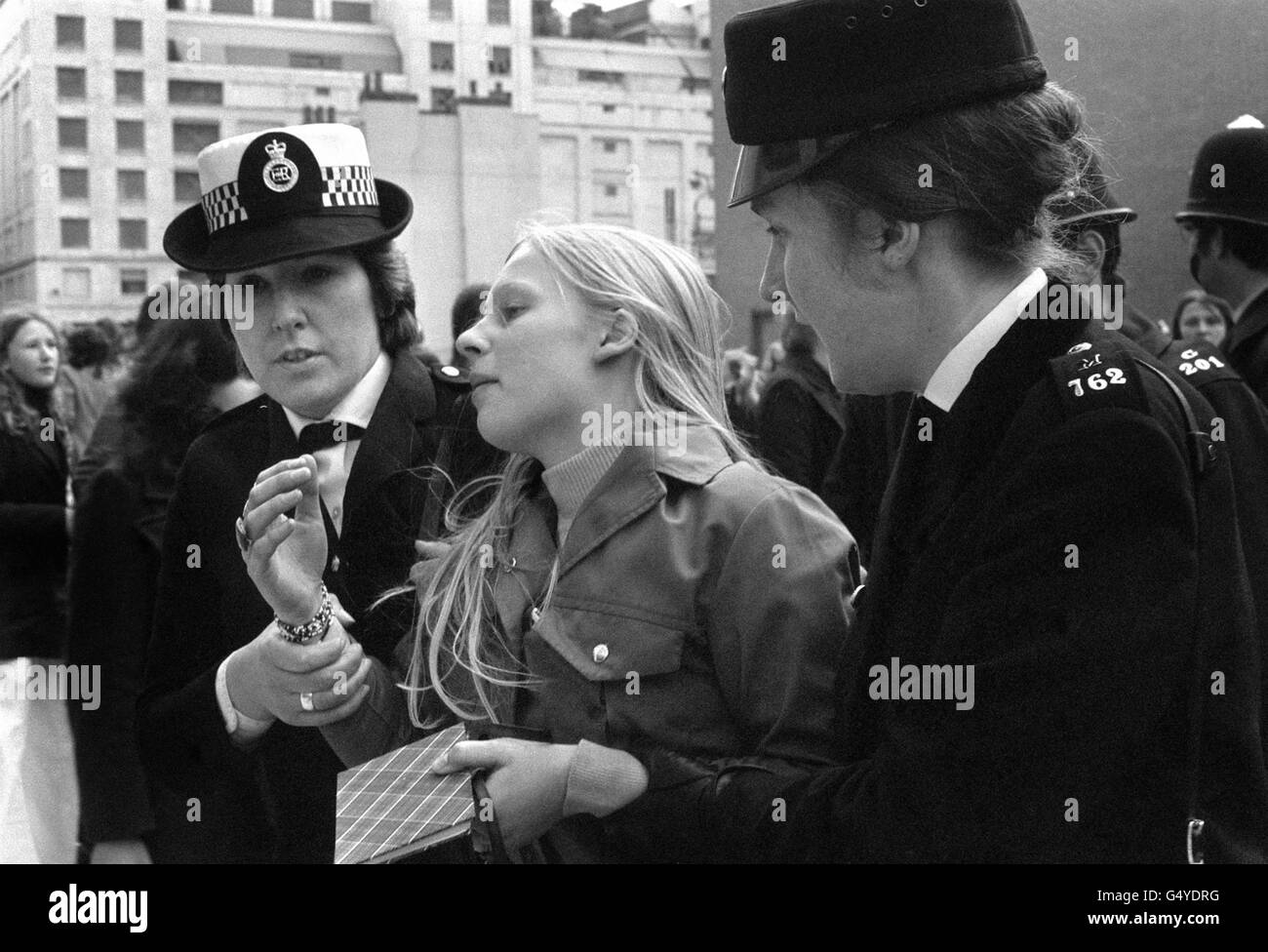 A girl helped away by policewomen after she had been knocked over in a rush of teeny-bopper fans hoping to glimpse American pop idol David Cassidy when he visited the London Weekend Television headquarters at Waterloo, London. Stock Photo