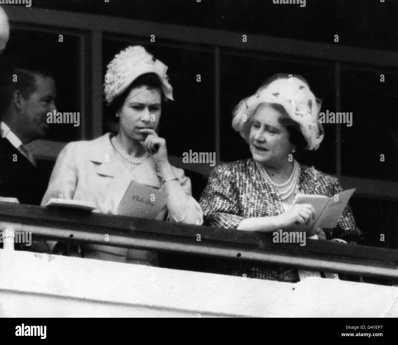 Queen Elizabeth II and the Queen Mother studying race cards in the Royal box on Oaks Day at Epsom, Surrey. They saw the Queen's entry 'Highlight', finish unplaced. Stock Photo