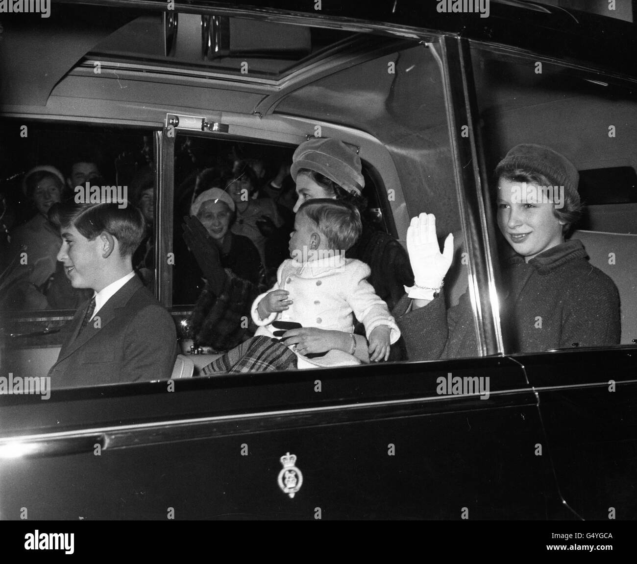 *Scanned low-res from print* Queen Elizabeth II with the Prince of Wales, Princess Anne and baby Prince Andrew driving from Buckingham Palace to Liverpool Street Station, to join other members of the Royal family at Sandringham for the Christmas holidays. Stock Photo