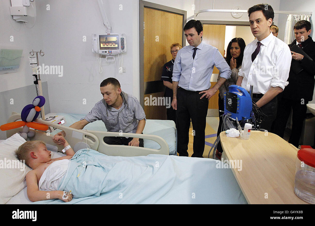 Labour leader Ed Miliband (right) and shadow health secretary Andy Burnham meet meet Steven Lowe and his son Lincoln, 4, during a visit to the Royal Bolton Hospital in Greater Manchester. Stock Photo