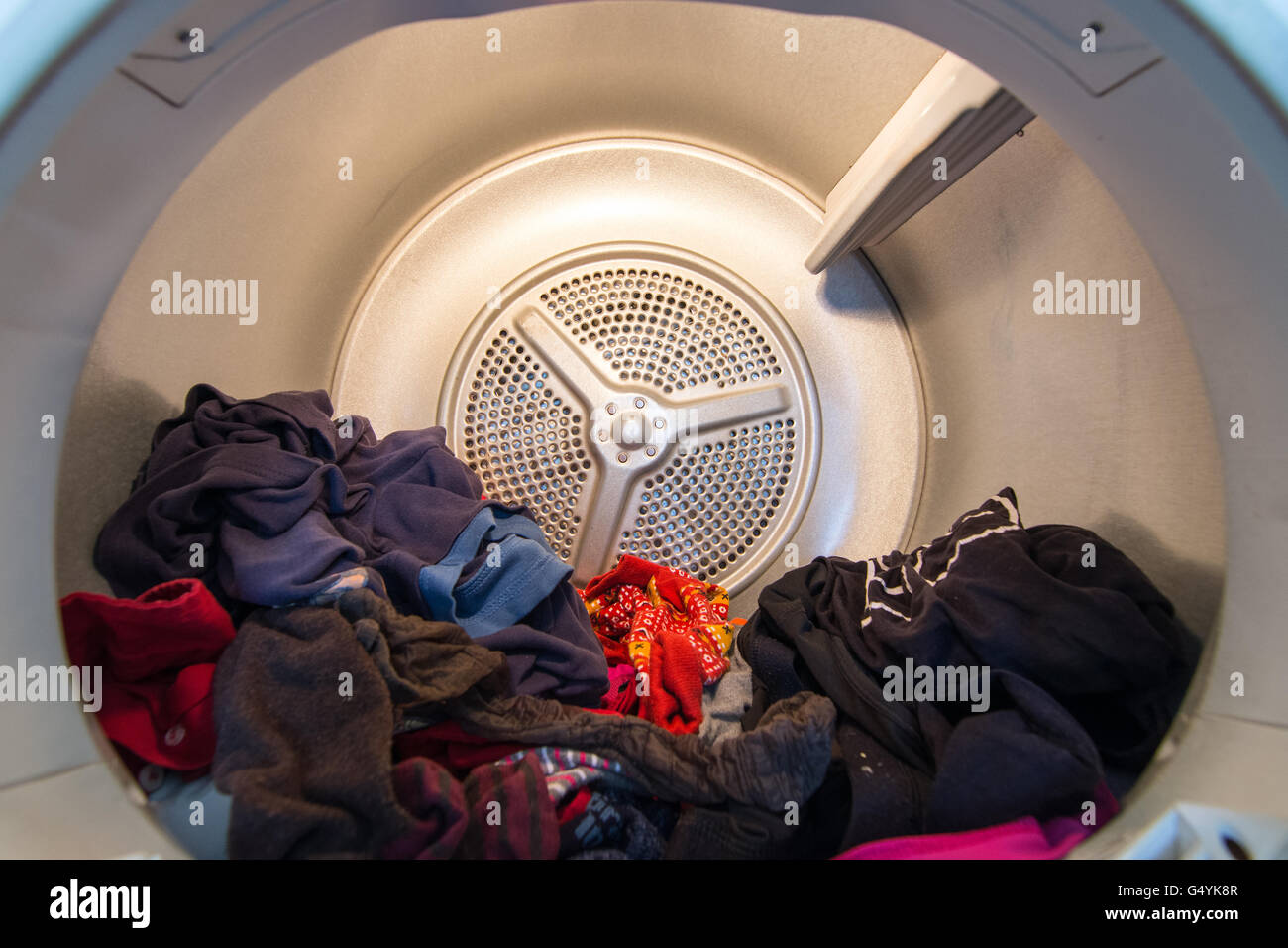 Inside view of a domestic tumble drier (clothes drier) with clothing in it Stock Photo