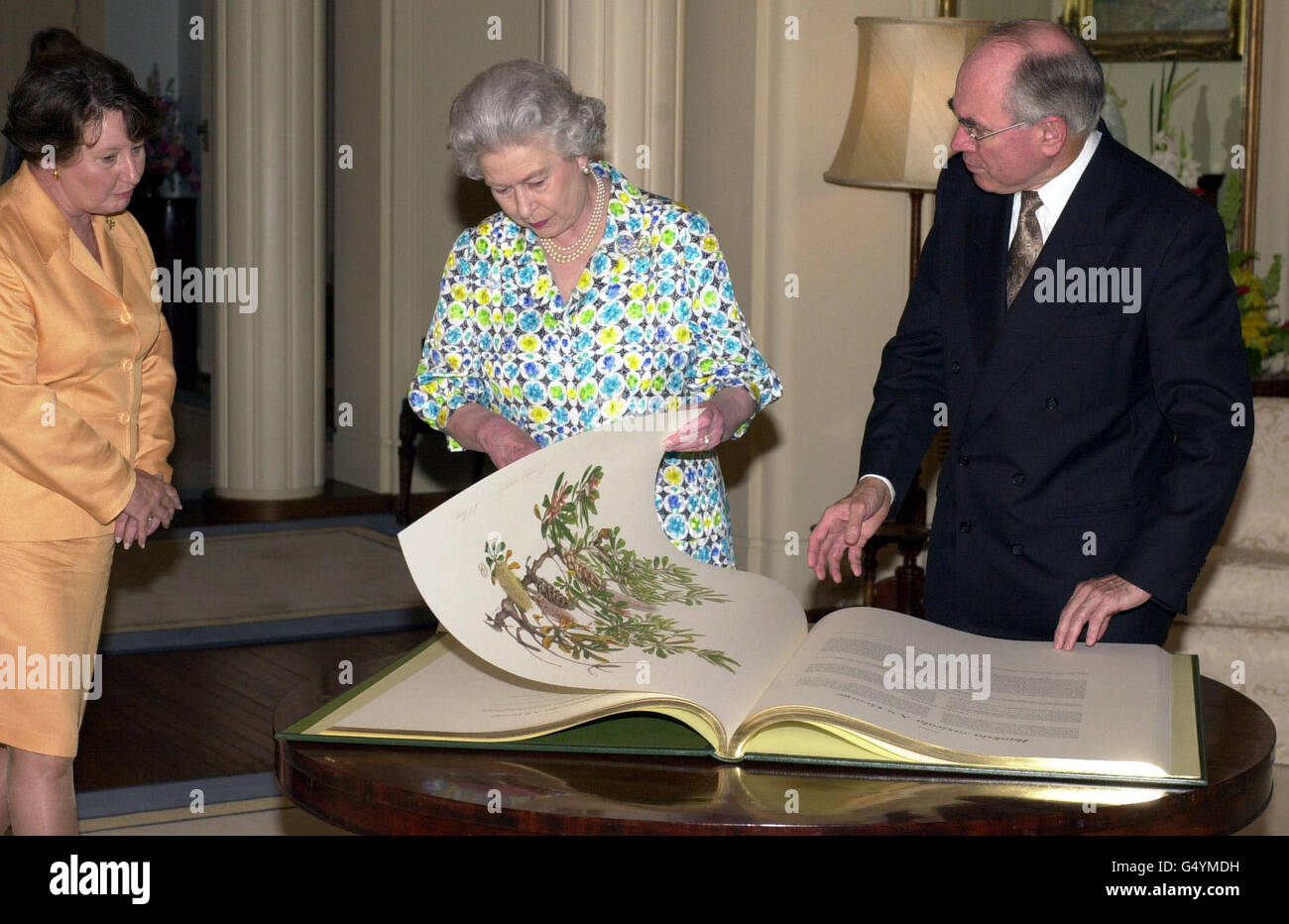 Britain's Queen Elizabeth II (C) with Australian Prime Minister John Howard and his wife Jeanette at Government House in Canberra, where she was presented with the third in a series of books of botanical prints, 'The Banksias'. Stock Photo