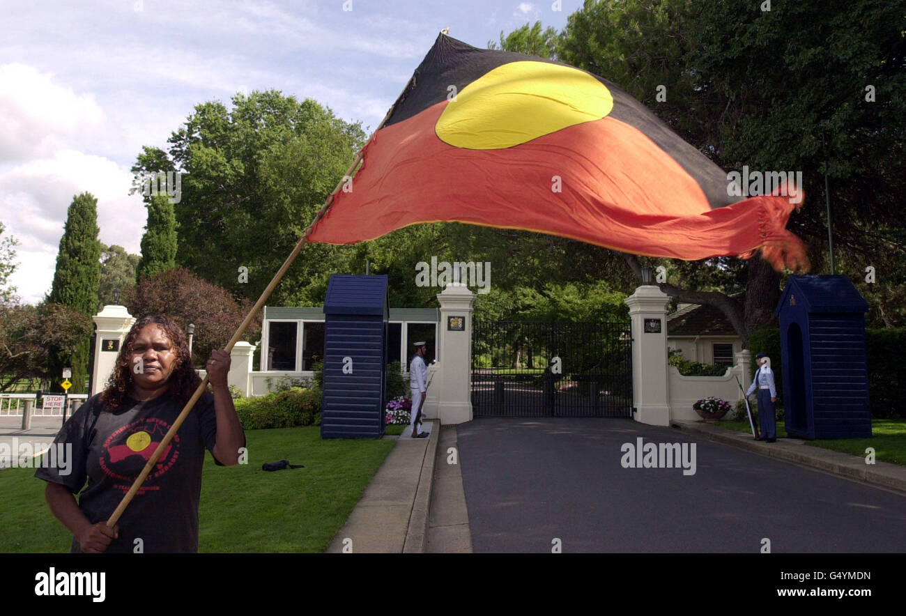 Aborigine, Donna Gibbs waves the Aboriginal flag outside Government House in Canberra while the Queen, who is staying there, met Australian Prime Minister John Howard and Governor General Sir William Deane. * Government House is the official residence of Governor Generals. Stock Photo