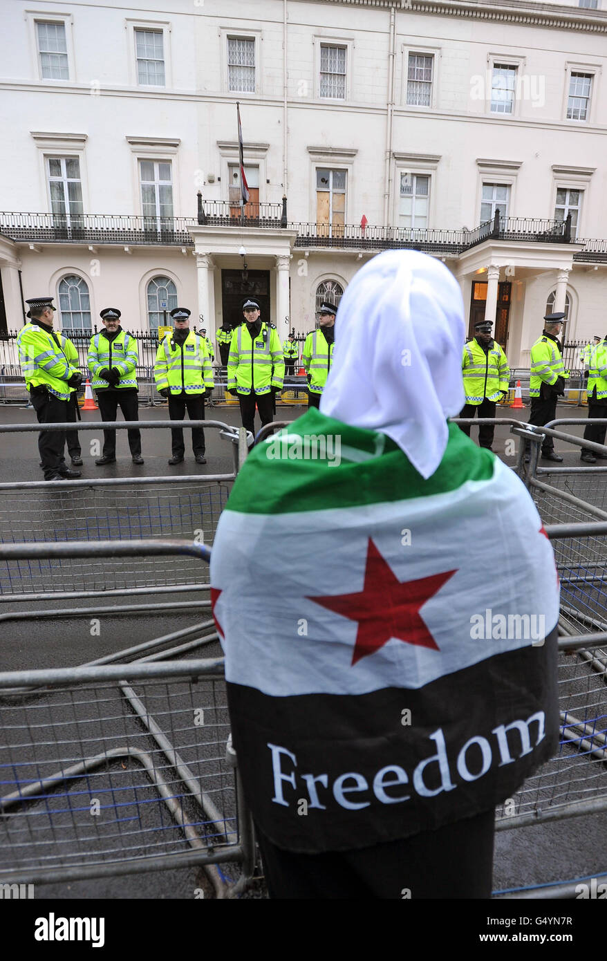 A woman wrapped in a Syrian flag as protesters outside the Syrian Embassy in Belgrave Square in central London, demonstrate about the escalating conflict in Syria. Stock Photo