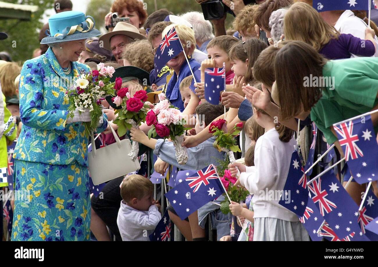 Queen Elizabeth II receives flowers from members of the crowd in Central Park, Bourke, Australia, a small settlement of 3,600 people, 500 miles (800kms) north west of Sydney. * Bourke is a byword in Australia for the remote outback. 'Back 'o Bourke' is an Australian colloquialism meaning the back of beyond or middle of nowhere. Stock Photo