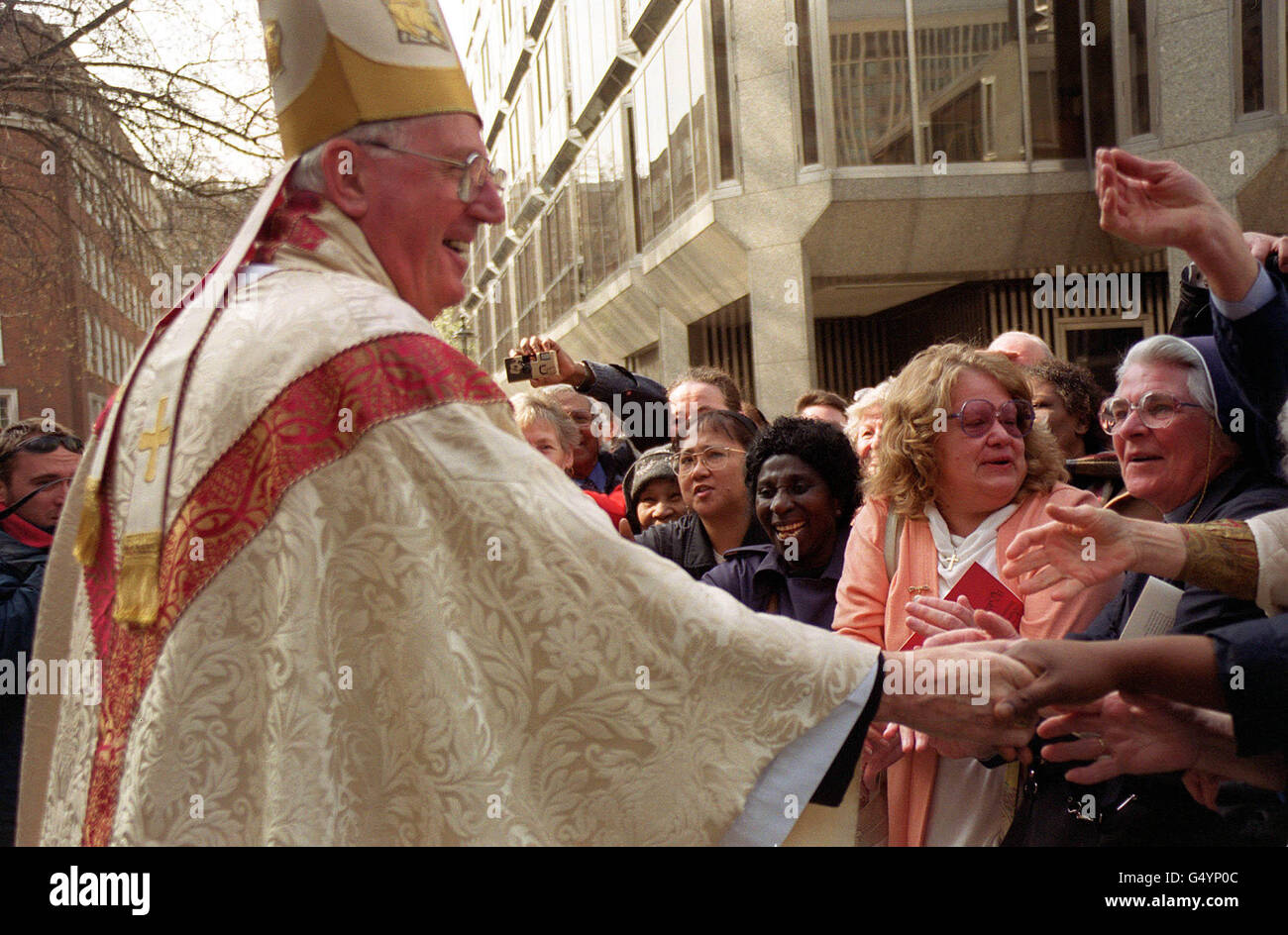 The new Archbishop of Westminster, the Most Rev Cormac Murphy-O'Connor, shakes hands with wellwishers on the steps of Westminster Cathedral in London, after his installation as head of the Roman Catholic church in England and Wales. Stock Photo