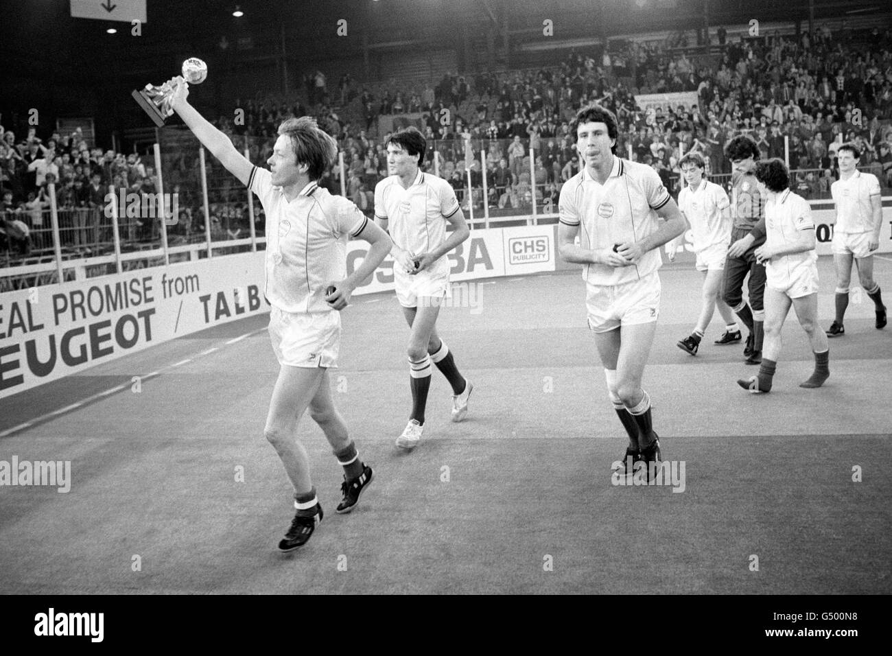 Birmingham City's Alan Curbishley (left) with the Atari Trophy after victory in the Atari Soccer Six Indoor Tournament. With him are (l-r) Mick Harford, Colin Brazier, Kevin Dillon, Tony Coton, Ian Handysides and Jim Hagan Stock Photo