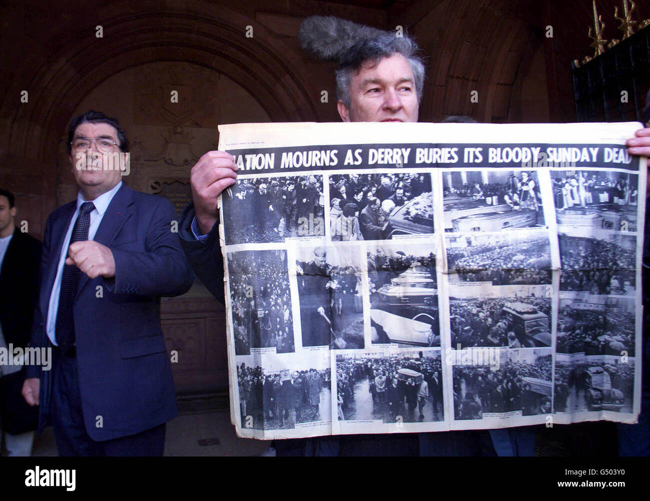 SDLP leader John Hume arrives at the Guildhall in Londonderry, for the start of the inquiry into the army shootings in 1972, known as Bloody Sunday, as a member of the public holds up a paper from the time of the shootings. *Oral hearings into the army killings in Northern Irelandy started with a statement by tribunal chairman, Lord Saville. Stock Photo