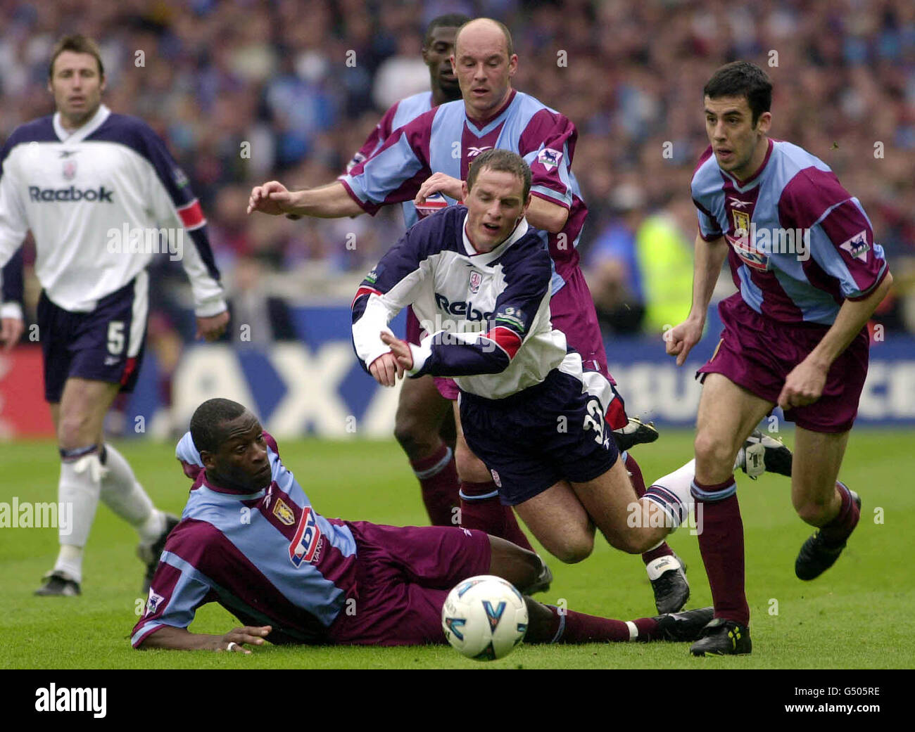 Allan Johnston of Bolton Wanderers trips over, with Aston Villa's Ian Taylor, (left), Steve