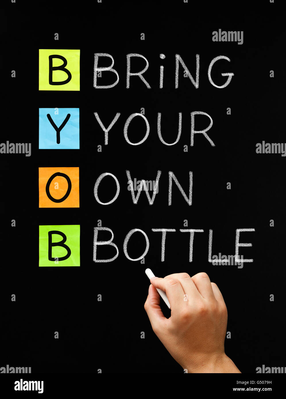 Hand writing BYOB Bring Your Own Bottle with white chalk on blackboard. Stock Photo
