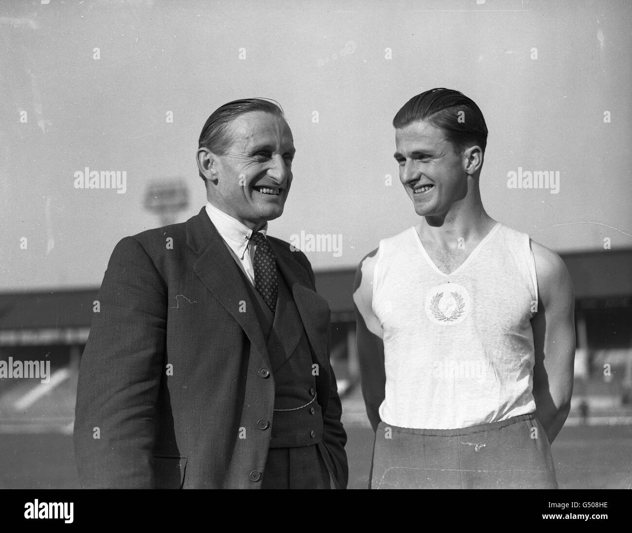 Ivor Vind (right) , Danish Athletic President of Cambridge University gets some helpful advice from Lord Burghley , famous Cambridge and Olympic athlete of pre-war days. Vind , who will probably be a member of the Danish Olympic team leads the University athletes against Oxford in the Inter-Varsity Sports at the White City . Stock Photo