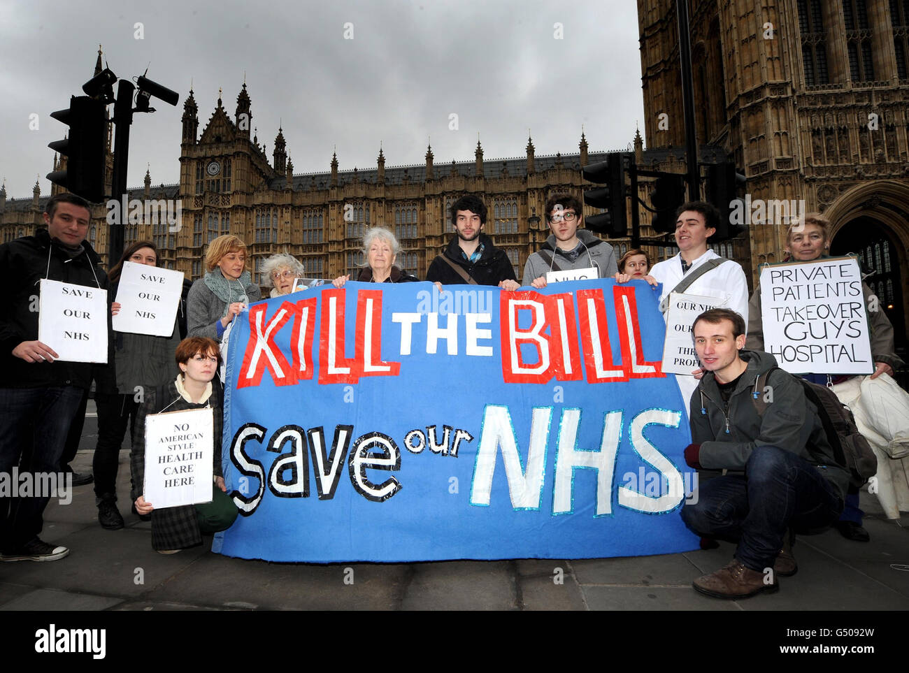 Nurses, pensioners and NHS workers pose for media after blocking the road outside the Houses of Parliament in London to protest against the the Government's controversial NHS reforms as the Health and Social Care Bill resumes its troubled passage through the House of Lords. Stock Photo