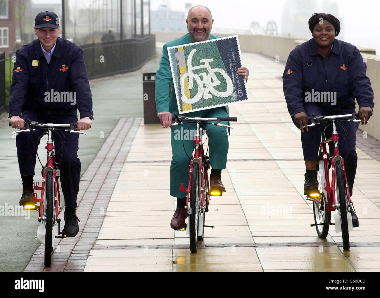 Comedian Alexei Sayle (C) with postman Steve North and postwoman Yetunde Sodiya, with the Royal Mail's latest set of Millennium Stamps which go on sale on 2/5/2000. The stamps promote the National Cycle Network. Stock Photo