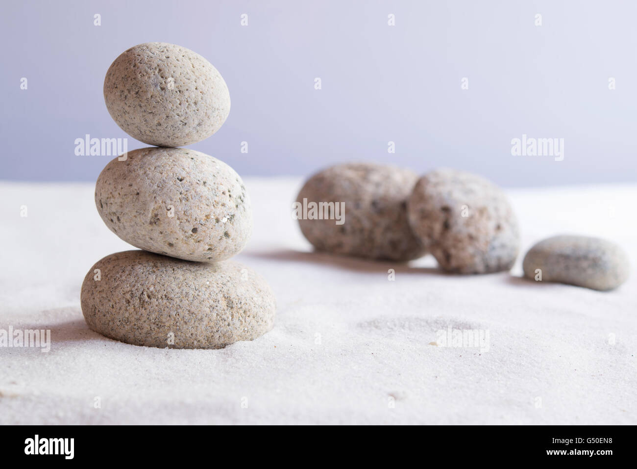 Meditative stones in balance on white sand Stock Photo