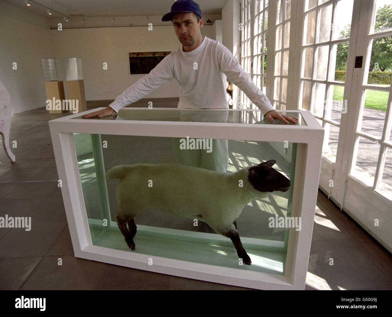 Controversial British artist, Damien Hirst, with 'Away from the Flock', a dead lamb suspended in formaldehyde, which features in an exhibition at London's Serpentine Gallery. Hirst, 28, has achieved notoriety with sculptures that concentrate on putrefaction. * 15/04/03 The Saatchi Gallery was being launched, with Damien Hirst's first living work as a prize exhibit. More than 1000 were being expected to attend the party to celebrate the collection. The gallery is situated in the County Hall building in London and will be housing some of the most celebrated Brit Art works. Stock Photo