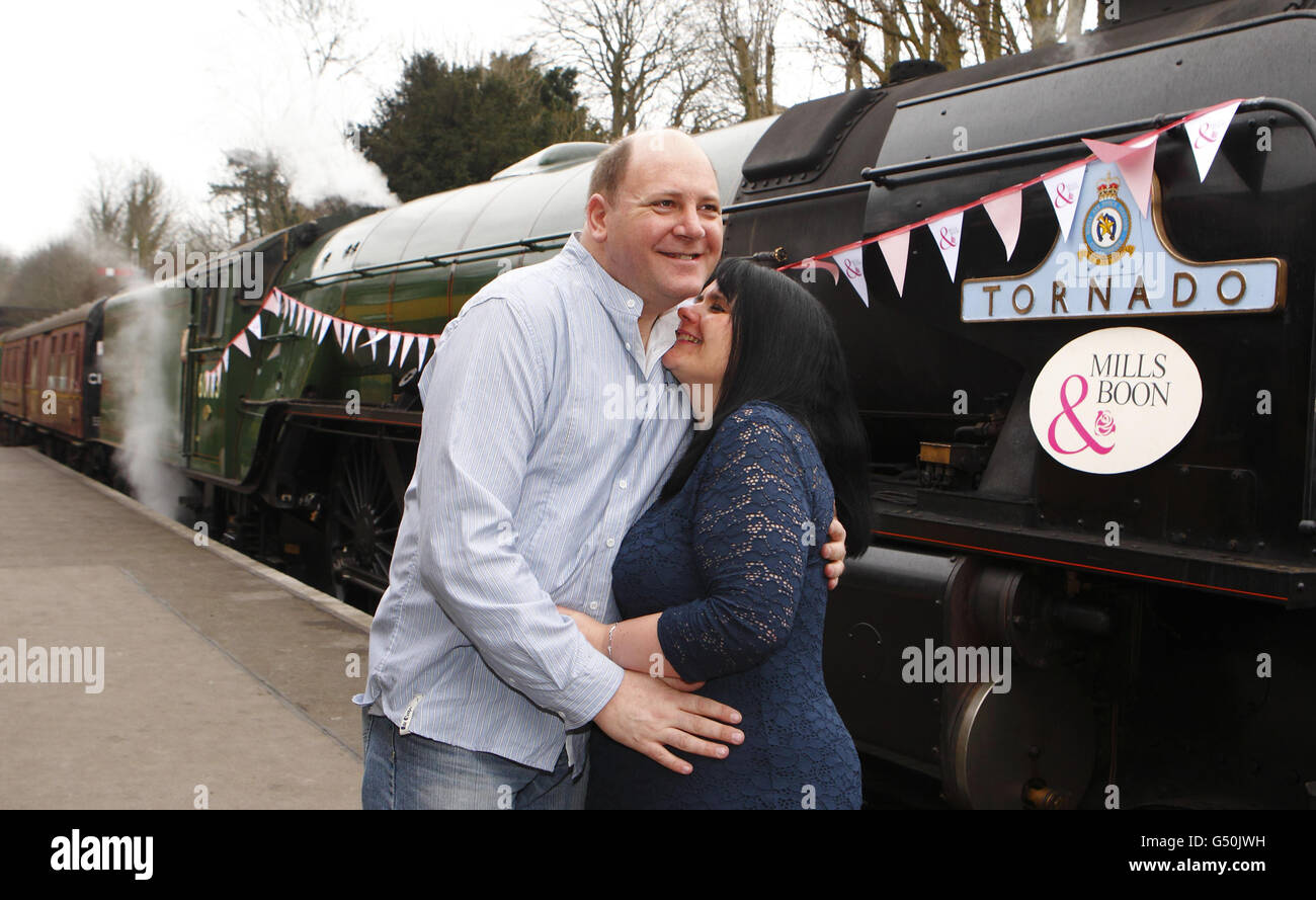 Fiona Boubert hugs her partner Neil Kennedy after she proposed to him on the Watercress Line steam railway at Alresford near Winchester, Hampshire. Stock Photo