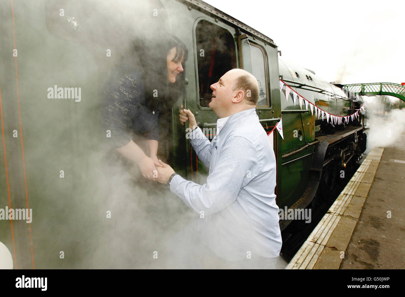 Fiona Boubert proposes to her partner Neil Kennedy on the Watercress Line steam railway at Alresford near Winchester, Hampshire. Stock Photo