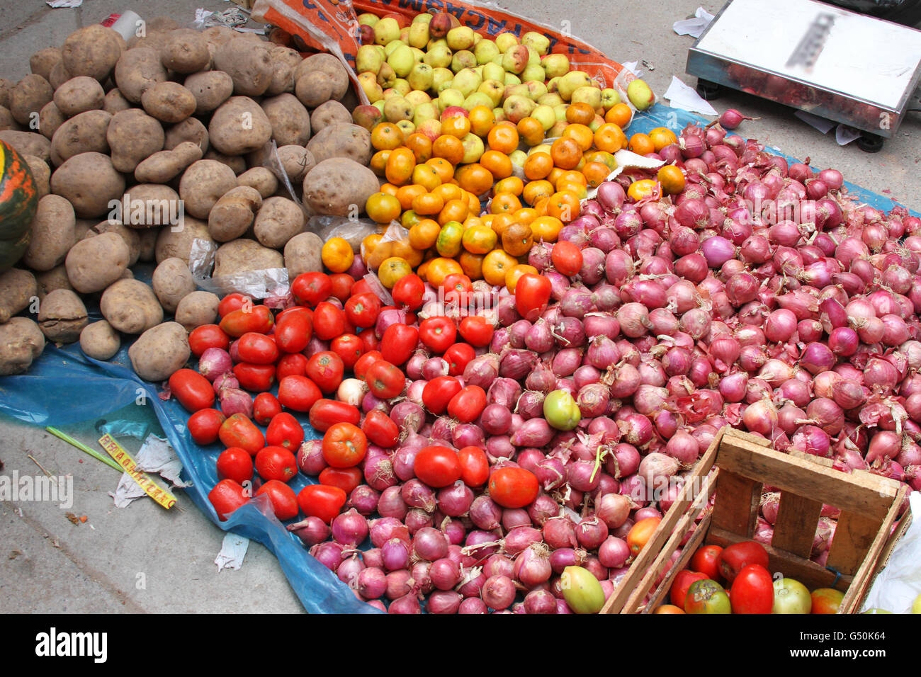 Onions, tomatoes, potatoes, apples and tangerines displayed on the ground at a Farmers' Market in Peru Stock Photo