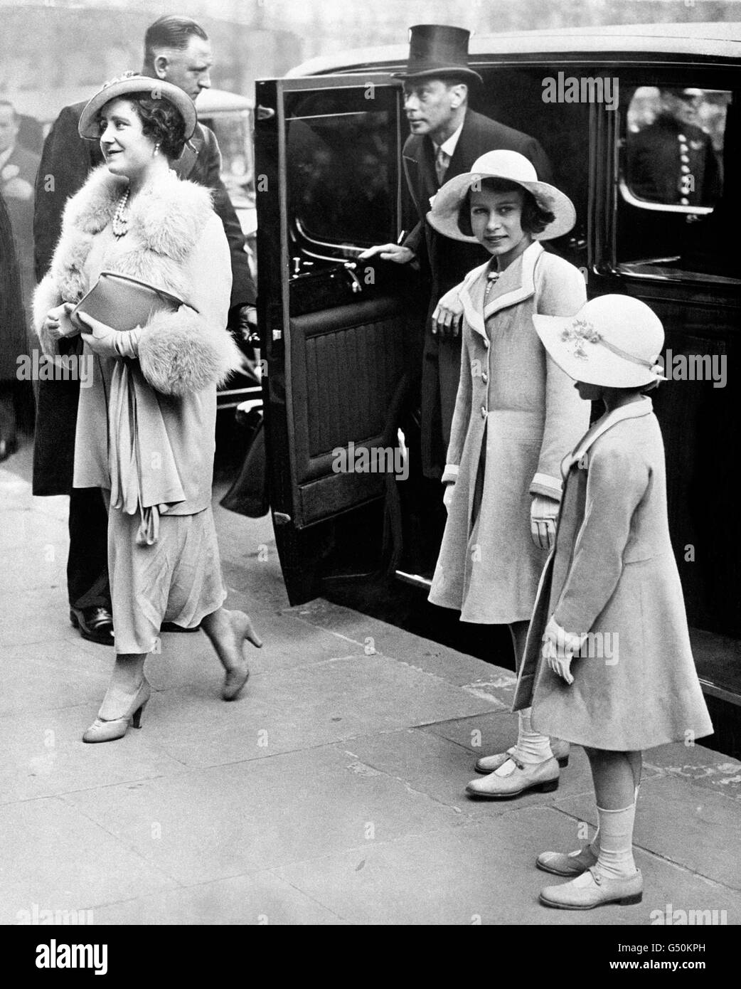 Queen Elizabeth and King George VI arriving with Princess Elizabeth, aged 11, and Princess Margaret (right) at Central Hall, Westminster, for the coronation concert for children. Stock Photo