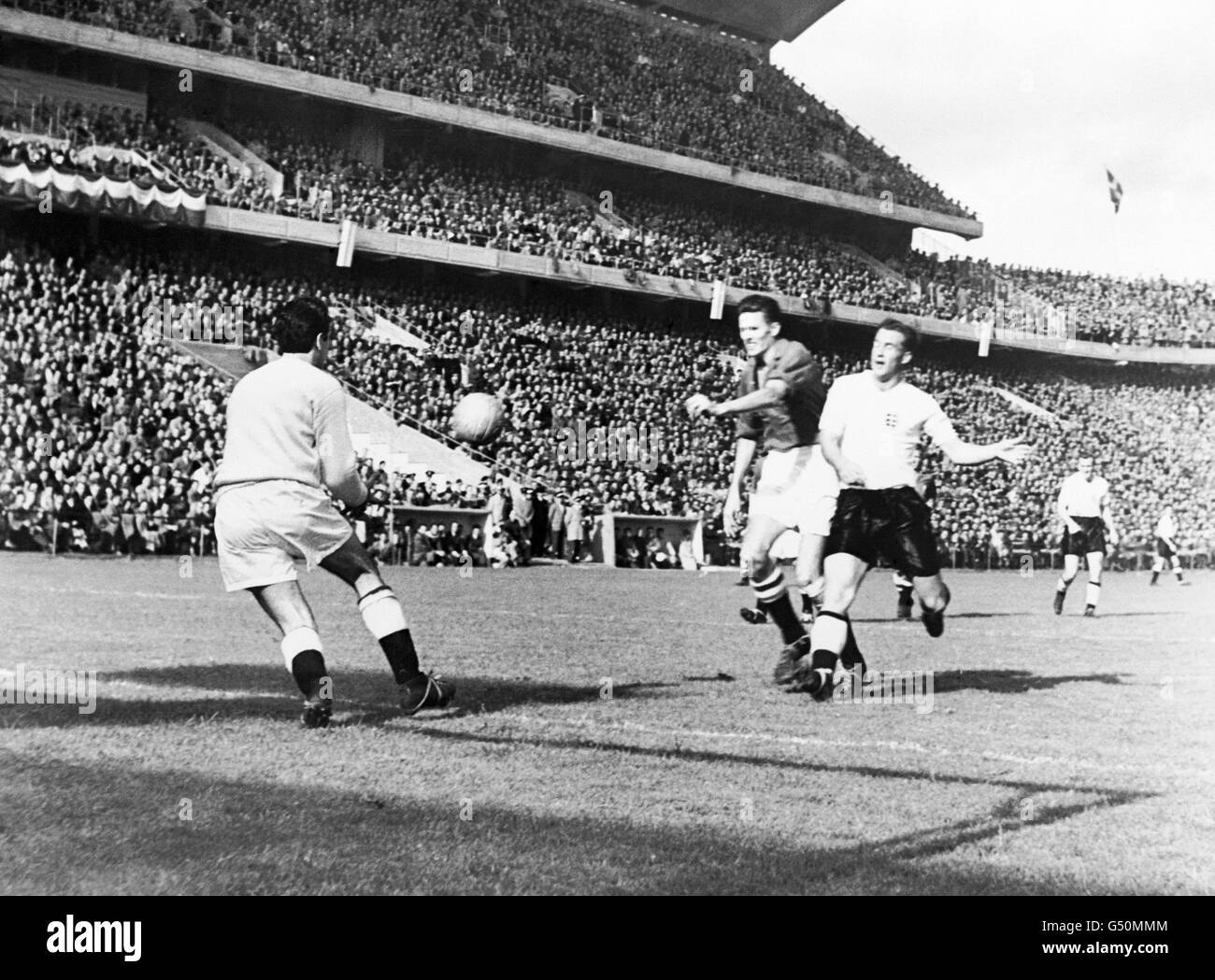 England's Nat Lofthouse sees his shot saved by Denmark goalkeeper Per Henriksen, watched by Denmark's Christen Brogger. Stock Photo