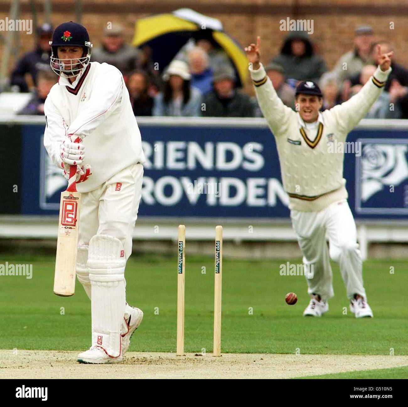 Lancashire's opening batsman John Crawley (L) is bowled by Durham's ...