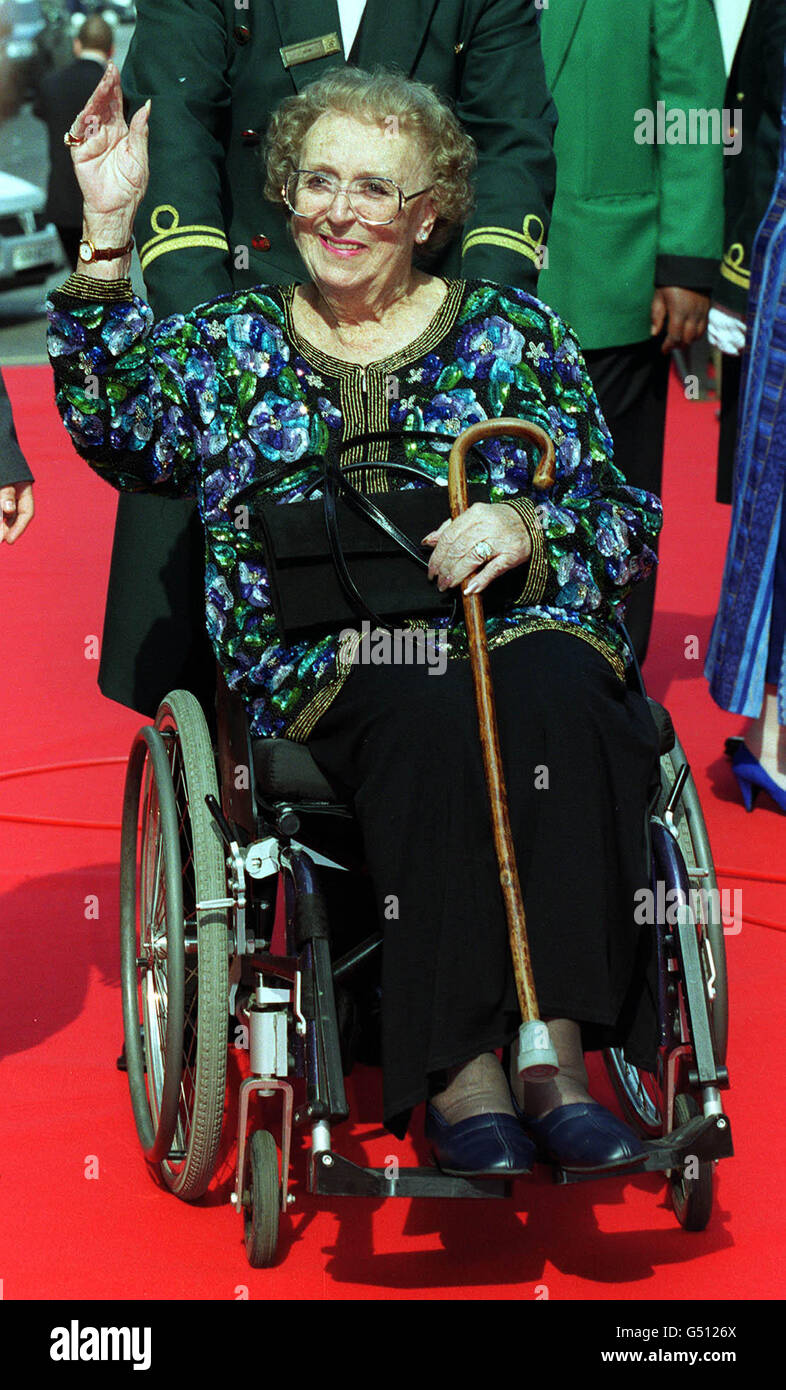 Celebrity arriving wheelchair walking stick smiling waving thora hird