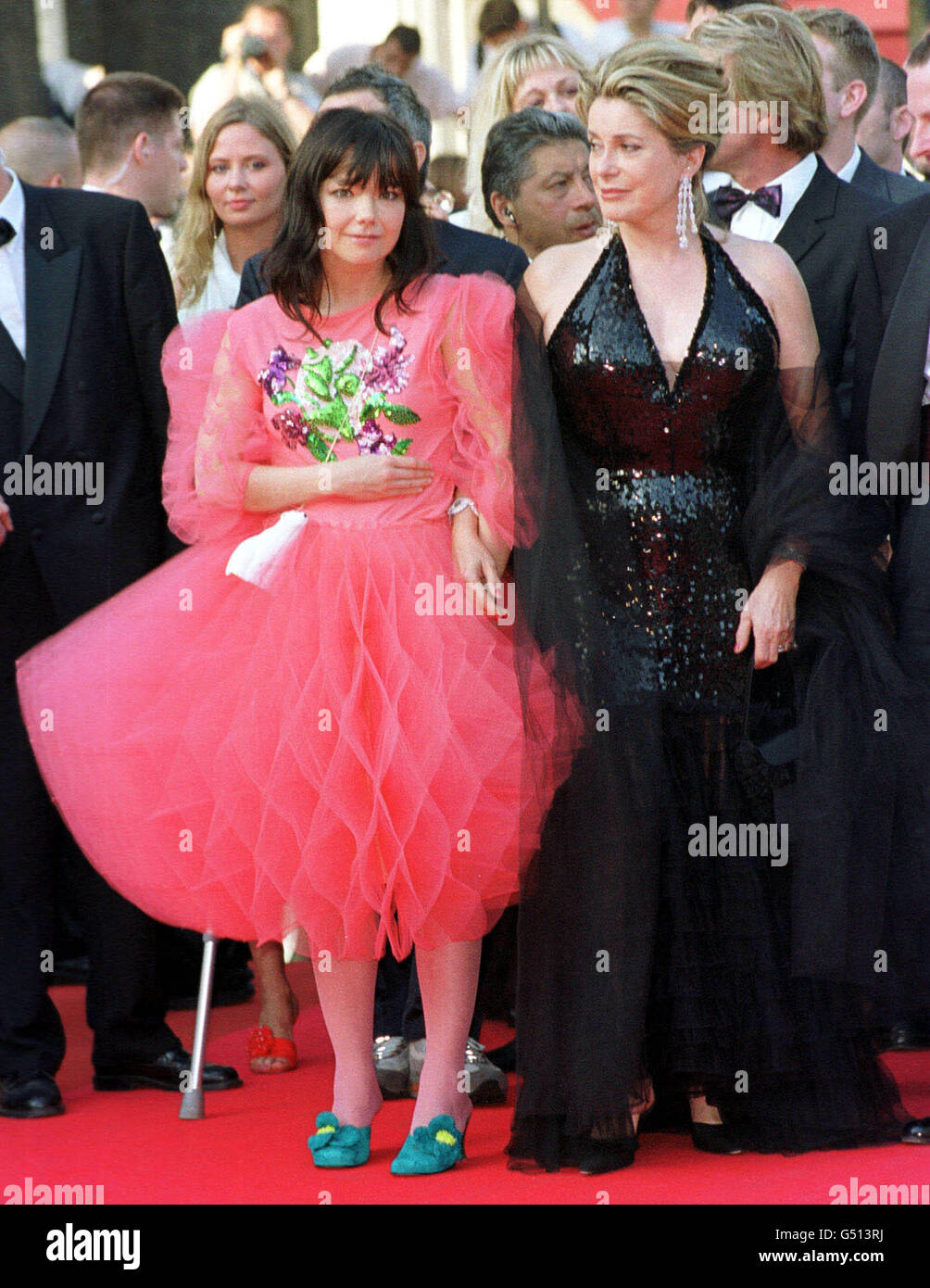 Singer Bjork from Iceland poses for photographers as she arrives at the premiere to 'Dancer in the Dark', in which she stars, with actress Catherine Deneuve (right) at the Cannes Film Festival, France. Stock Photo