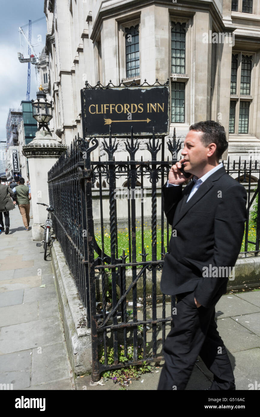 A suited man standing next to Clifford's Inn signage, Chancery Lane, London, UK Stock Photo