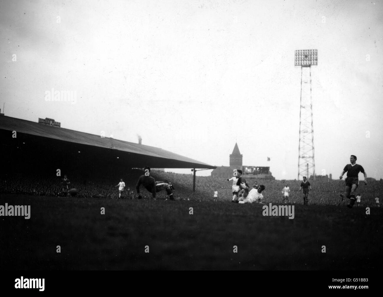 Manchester United goalkeeper Ray Wood falls, Real Madrid 's outside right Raymond Kopa goes down as well (right) but he scores the vital first goal for his team at the European Cup semi-final match at Old Trafford, Manchester. Stock Photo