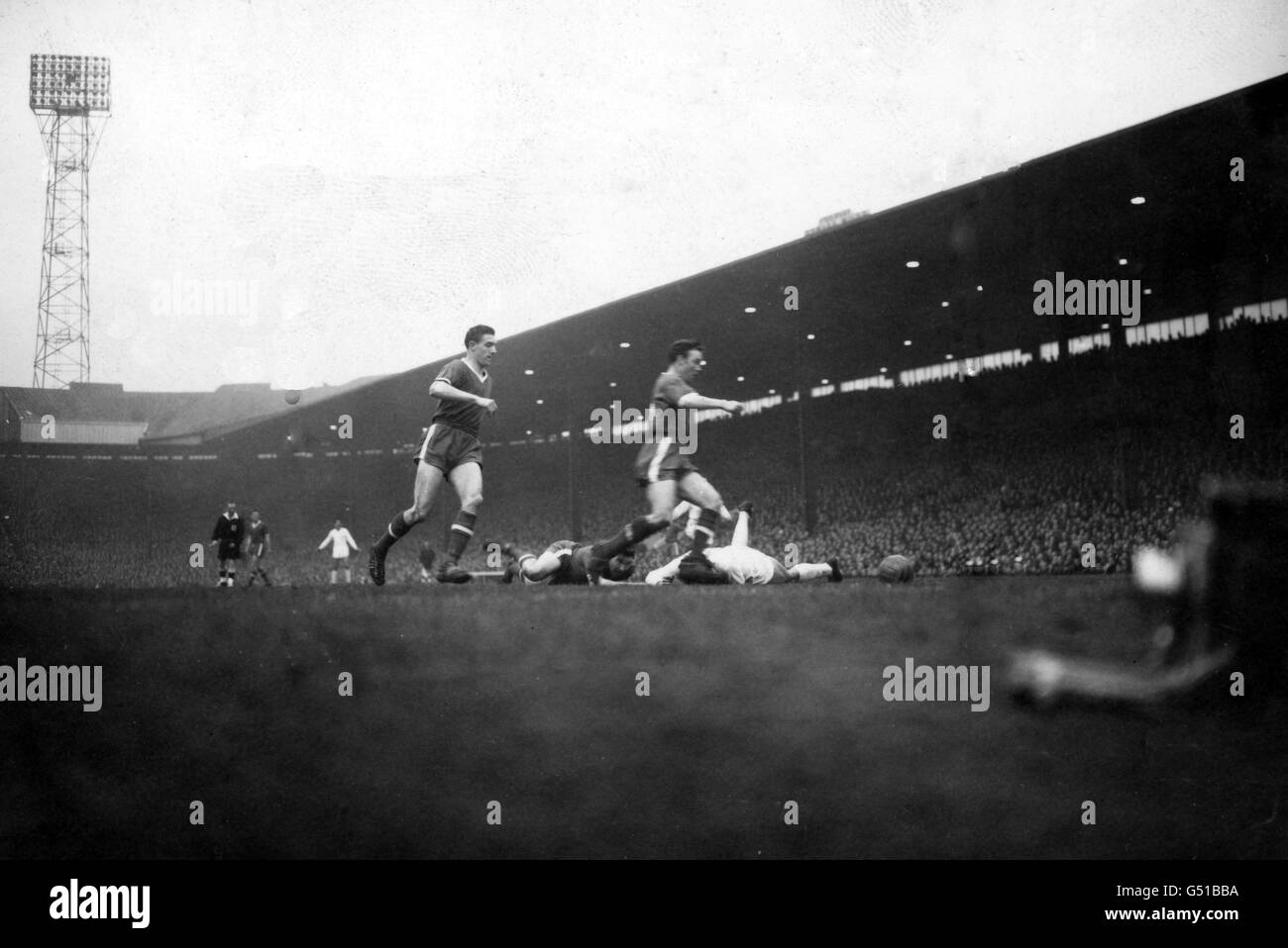 Bill Foulkes, Manchester United right back (left of picture), and Eddie Colman, Manchester United's right half, come to the assistance of their centre-half John 'Jackie' Blanchflower who has rolled on the ground with a Real Madrid player (white shirt) during the European Cup semi-final, second leg match. result was a 2-2 draw giving Real Madrid a winning aggregate of 5-3 Stock Photo