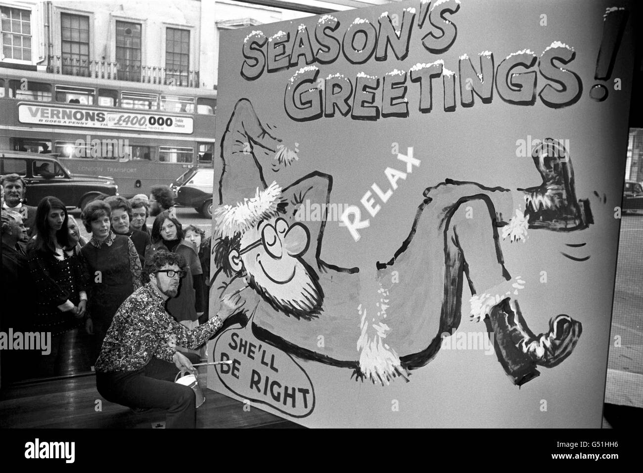 Window shoppers get a free seasonal greeting in the form of an 8' X 8' painting by entertainer Rolf Harris, in the window of the offices of the Western Australian Government in London. Stock Photo