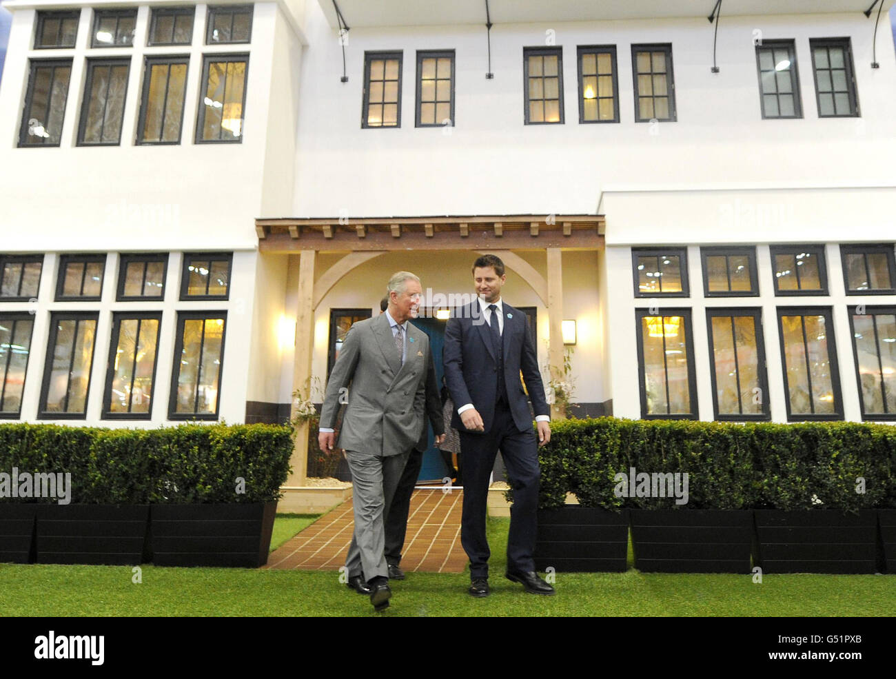 The Prince of Wales (left) and George Clarke leave a show house as the Prince officially opens the Ideal Home Show, Earl's Court, London. Stock Photo