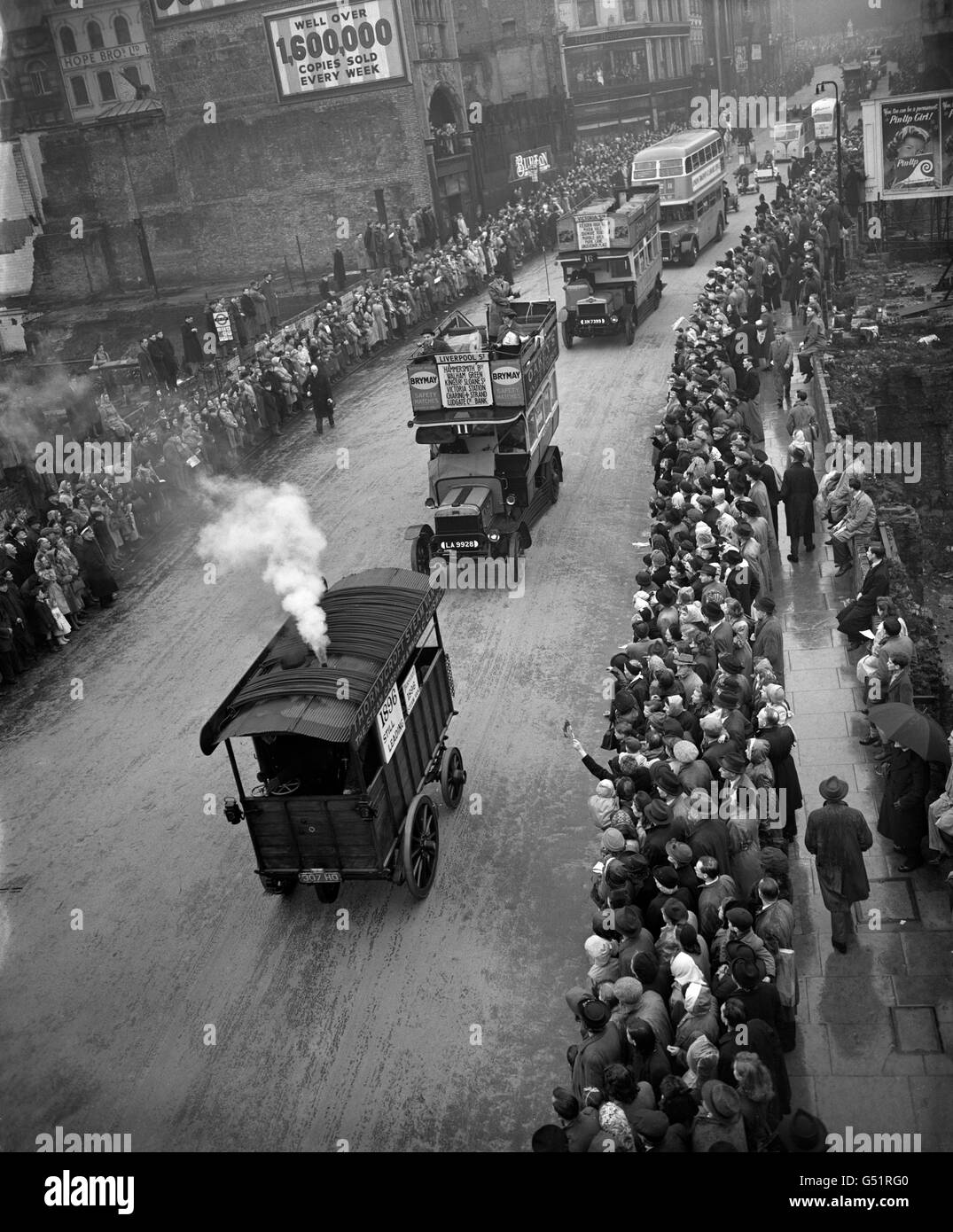 An old steam wagon puffs down Ludgate Hill followed by period motor buses from London Transport in the Lord mayor's procession to the Royal Courts of Justice. Stock Photo