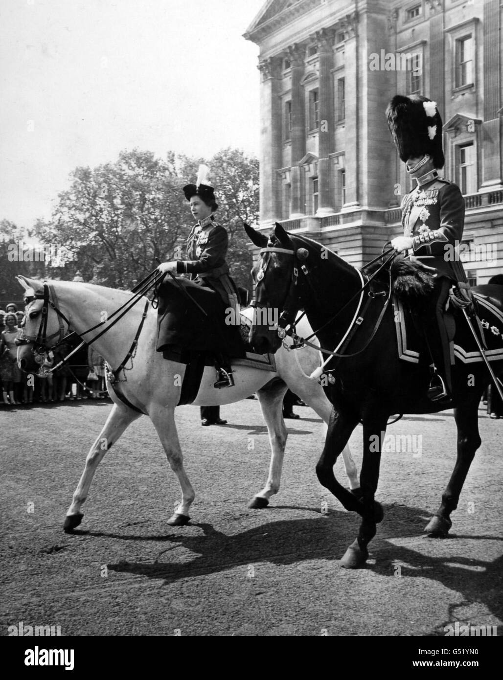 Queen Elizabeth II riding side-saddle on a new mount - a grey police horse named Doctor - leaves Buckingham Palace with the Duke of Edinburgh for the Trooping the Colour ceremony on the Horse Guards Parade. Stock Photo