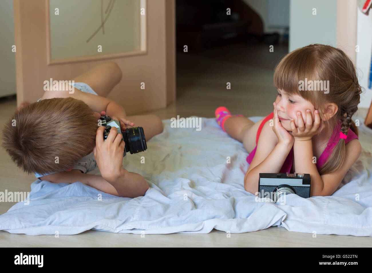 Little boy taking a picture of a little girl Stock Photo. 