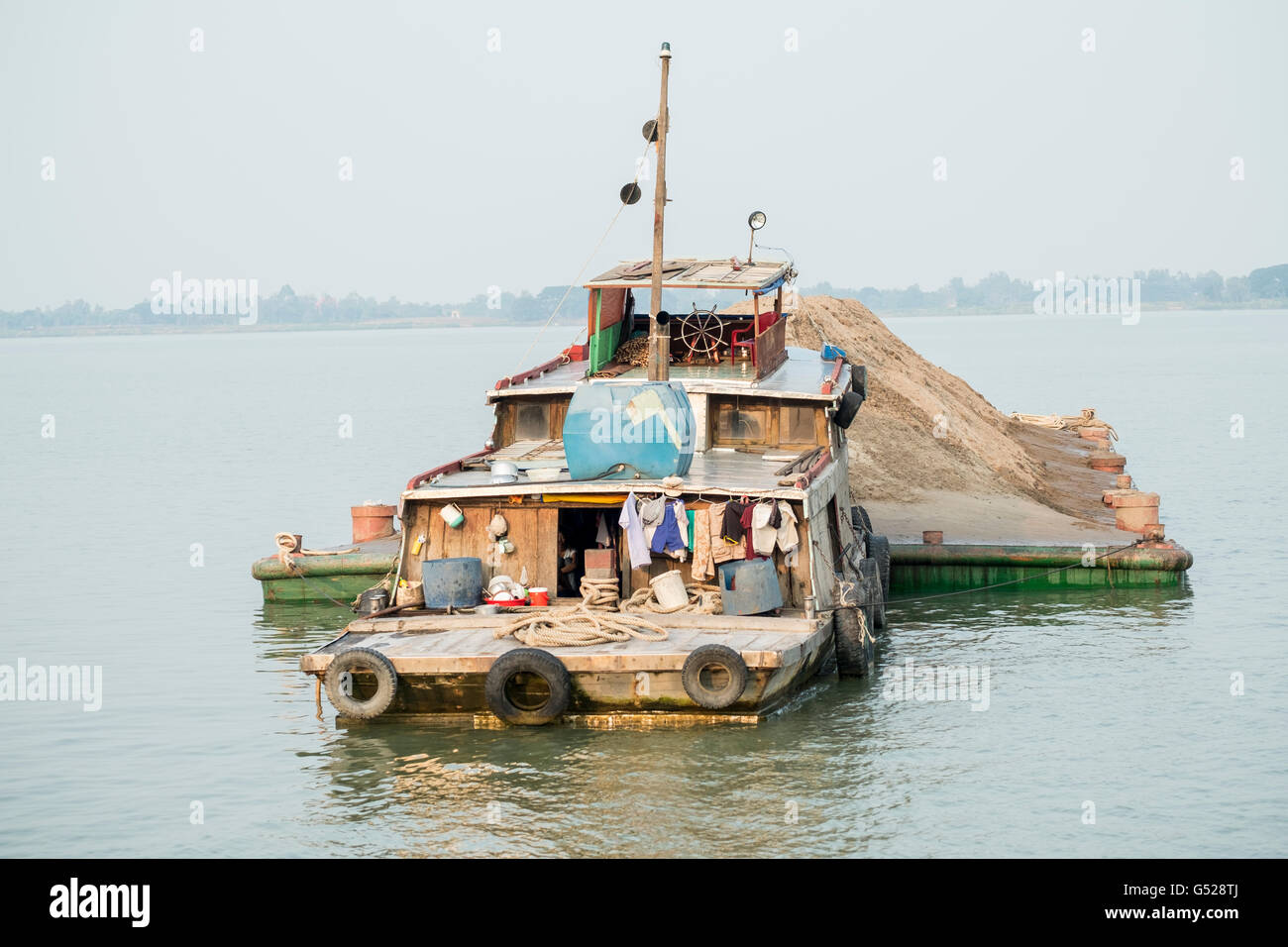 Sand dredger raft on the Mekong River in Cambodia - dredging sand for cement Stock Photo
