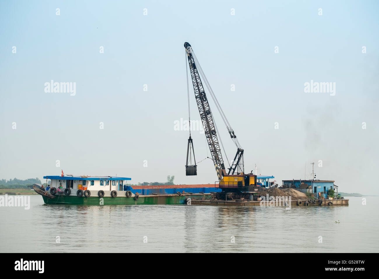 Dredgers mining sand and gravel for cement on the Mekong Stock Photo