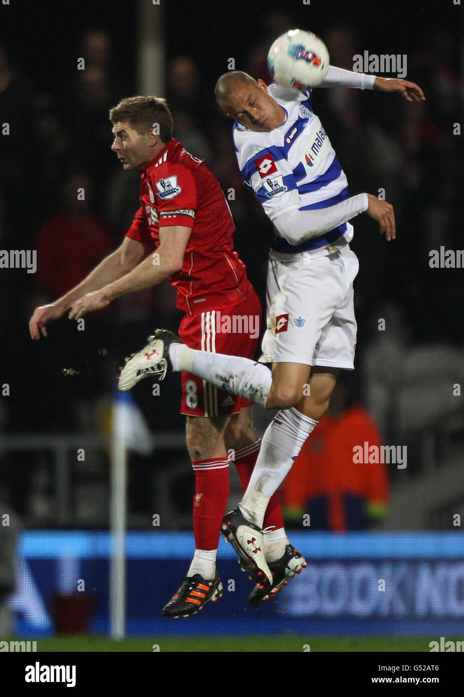 Queens Park Rangers' Bobby Zamora (right) wins the header beating Liverpool's Steve Gerrard during the Barclays Premier League match at Loftus Road, London. Stock Photo