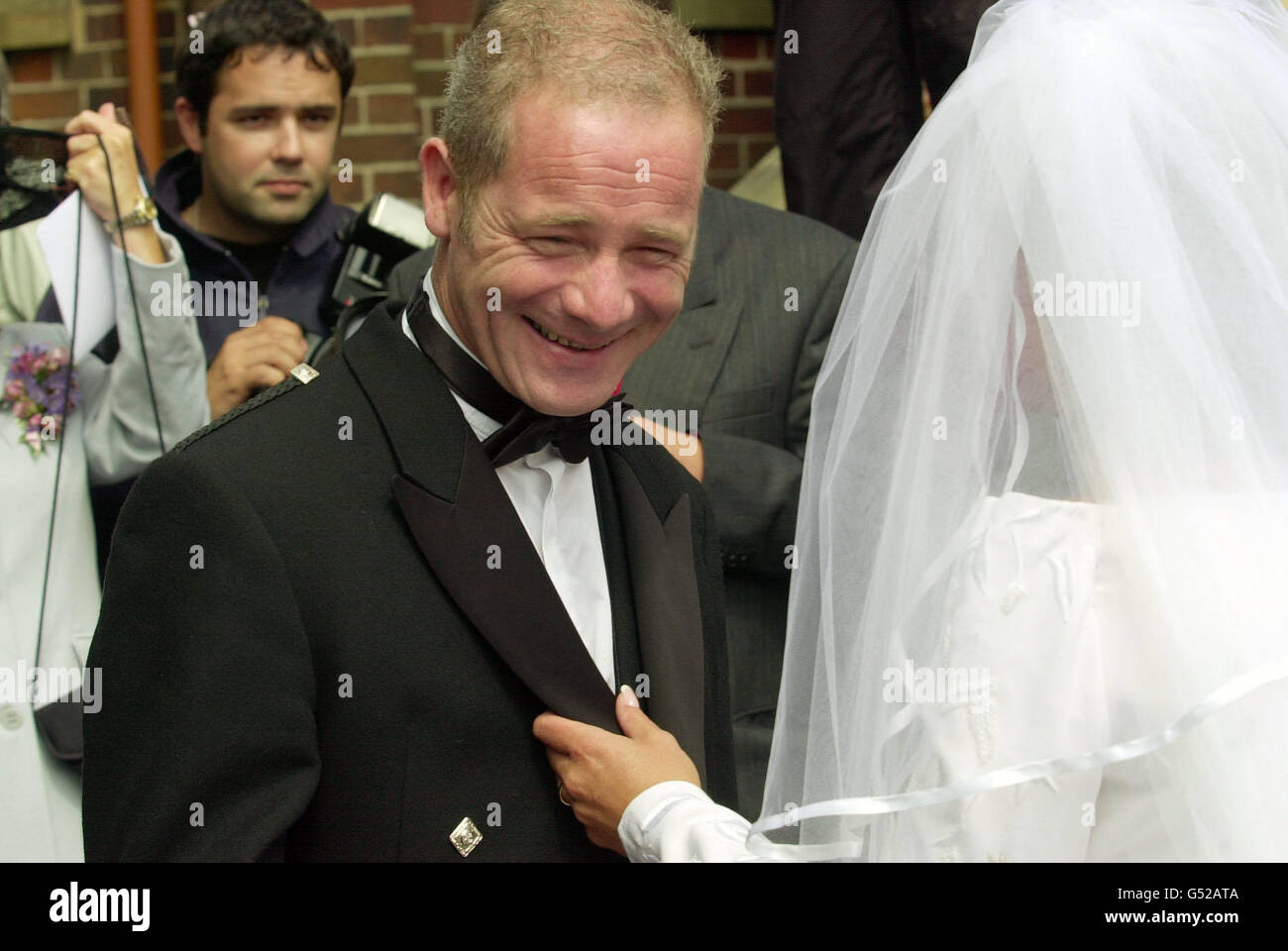 Scottish actor Peter Mullan talks to bride Gail Healy at her wedding to Scottish Socialist MSP Tommy Sheridan at the Our Lady of Lourdes Church in the Cardonald area of Glasgow. Stock Photo