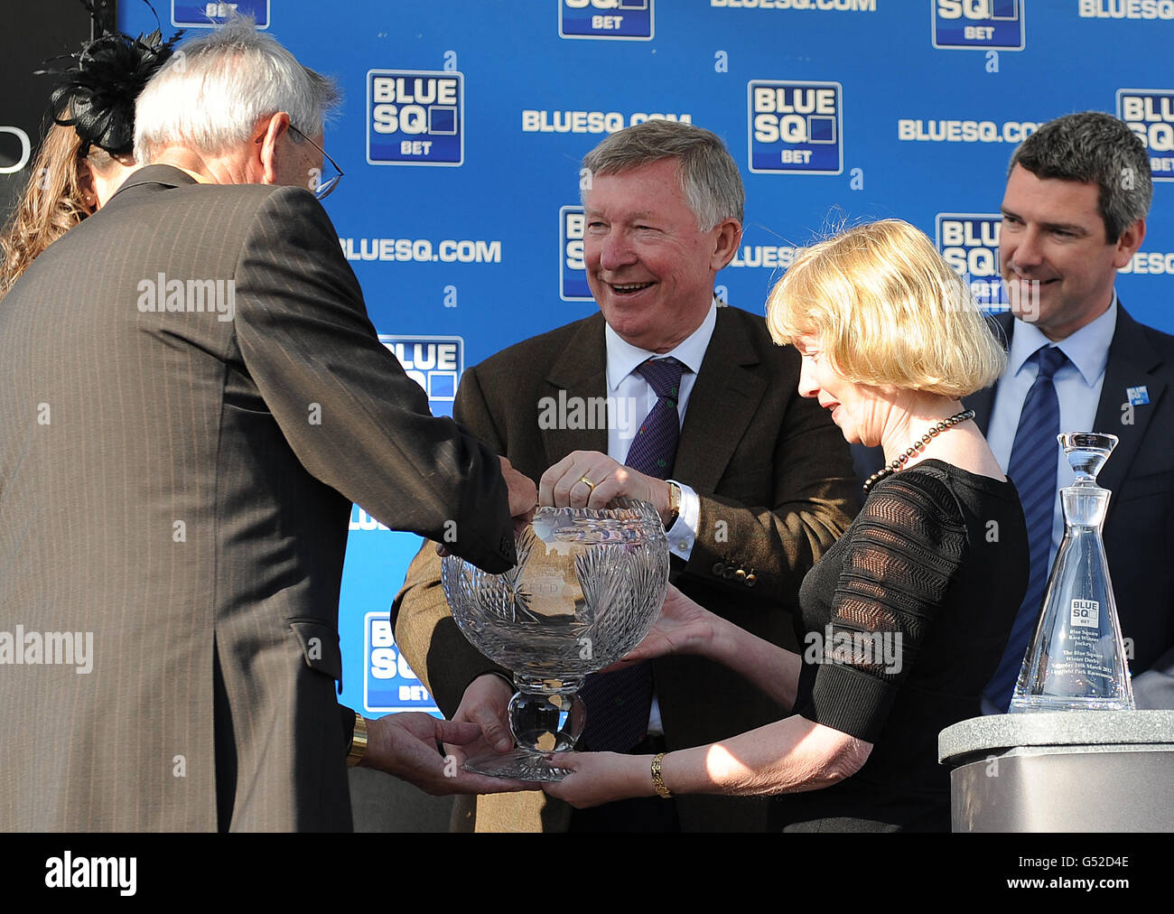 Sir Alex Ferguson collects his prize after his horse, Forgotten Hero (Michael Hills won The Follow Us On Twitter @bluesq Maiden Stakes. Stock Photo