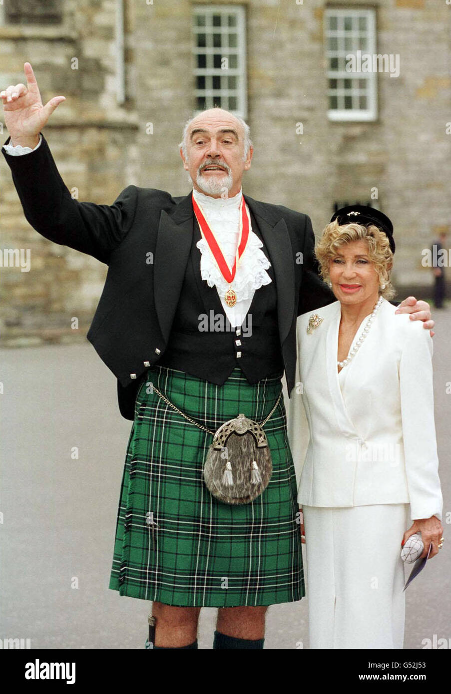 Sir Sean Connery, with wife Micheline, donning full Highland dress and wearing his medal after he was formally knighted by the Queen during a ceremony in his home city. * The Scottish screen legend, who was honoured at the Palace of Holyroodhouse in Edinburgh, knelt while the Queen touched his shoulders lightly with a sword and made him a Knight during the ceremony in the Palace's Picture Gallery. Stock Photo