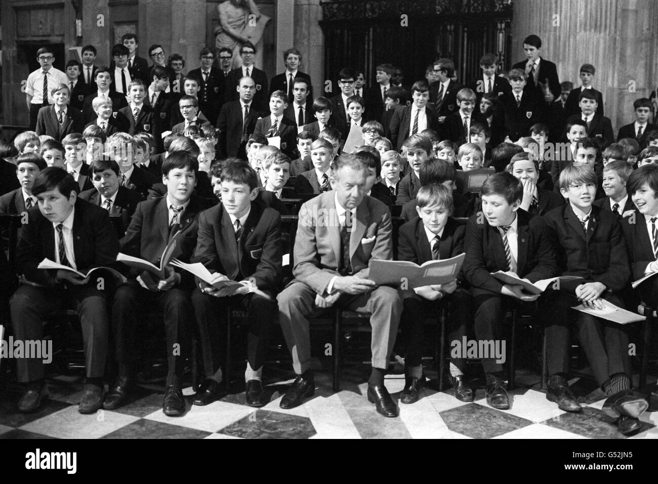 Benjamin Britten, seated in the front row with some of the Wandsworth School Boy's Choir in St. Paul's Cathedral, when they rehearsed his latest work 'Children's Crusade', Op.82, a ballad for children's voices and orchestra. The work was written to mark the occasion of the Jubilee of The Save the Children Fund. It will be sung by the Wandsworth School Boy's choir at the Fund's Interdenominational Thanksgiving Service at St. Paul's Cathedral and at the Aldeburgh Festival in June by the same choir. The words were taken from the text of German poet and dramatist Bertold Brecht, and the ballad Stock Photo