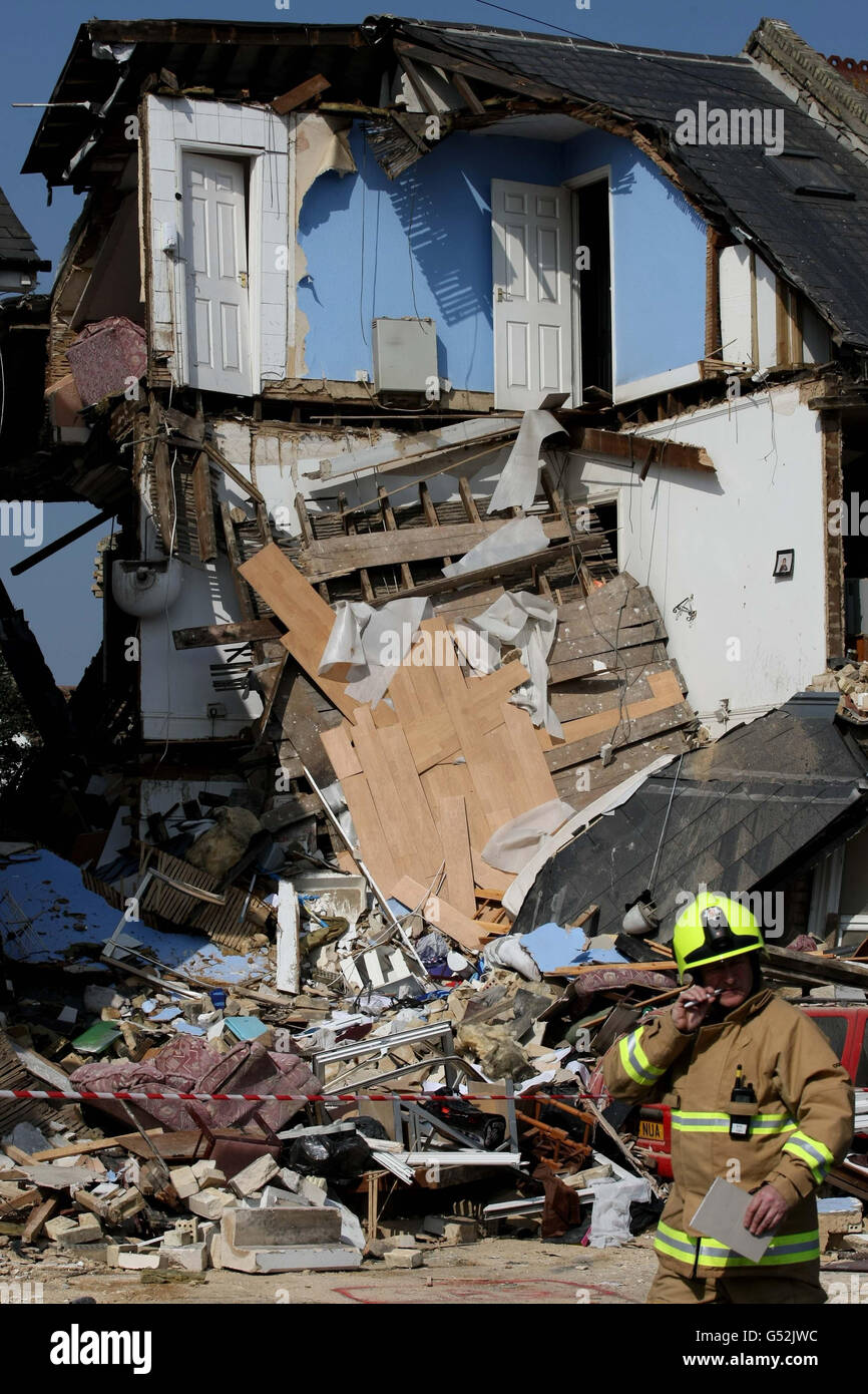 Fire and Rescue workers survey the scene at a house, divided into three