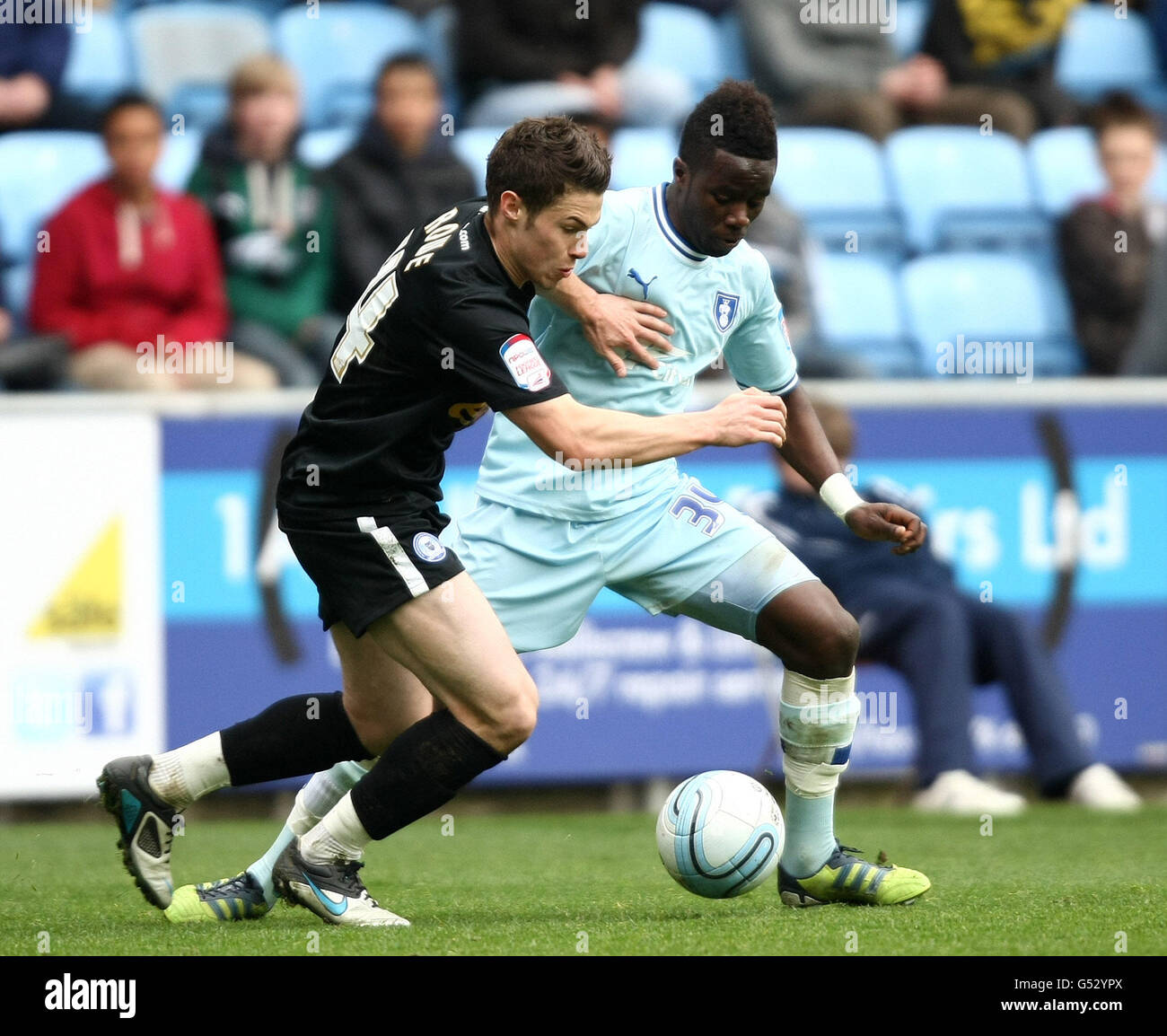 Coventry City's Gael Bigirimana and Peteborough United's Tommy Rowe during the npower Football League Championship match at the Ricoh Arena, Coventry. PRESS ASSOCIATION Photo. Picture date: Saturday April 7, 2012. Photo credit should read:PA Wire. RESTRICTIONS. Maximum 45 images during a match. No video emulation or promotion as 'live'. No use in games, competitions, merchandise, betting or single club/player services. No use with unofficial audio, video, data, fixtures or club/league logos. Stock Photo