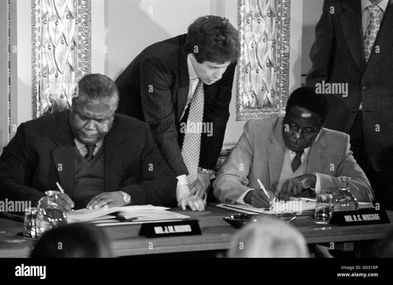 Guerrilla leaders Joshua Nkomo (L) and Robert Mugabe (R) signing the Rhodesia ceasefire agreement for the Patriotic Front at Lancaster House in London. Stock Photo