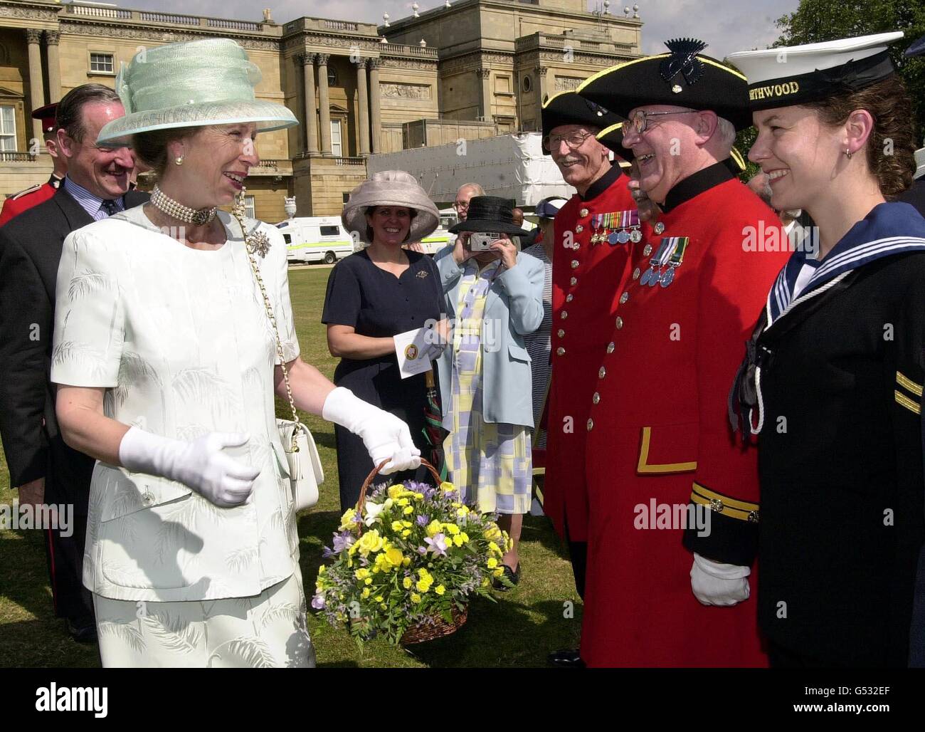 The Princess Royal (left) greets Chelsea Pensioner Geoff Payne, 71, (second right) and LWTR Fiona Devlin during the Not Forgotten Garden Party attended by the Princess Royal in the grounds of Buckingham Palace. Stock Photo