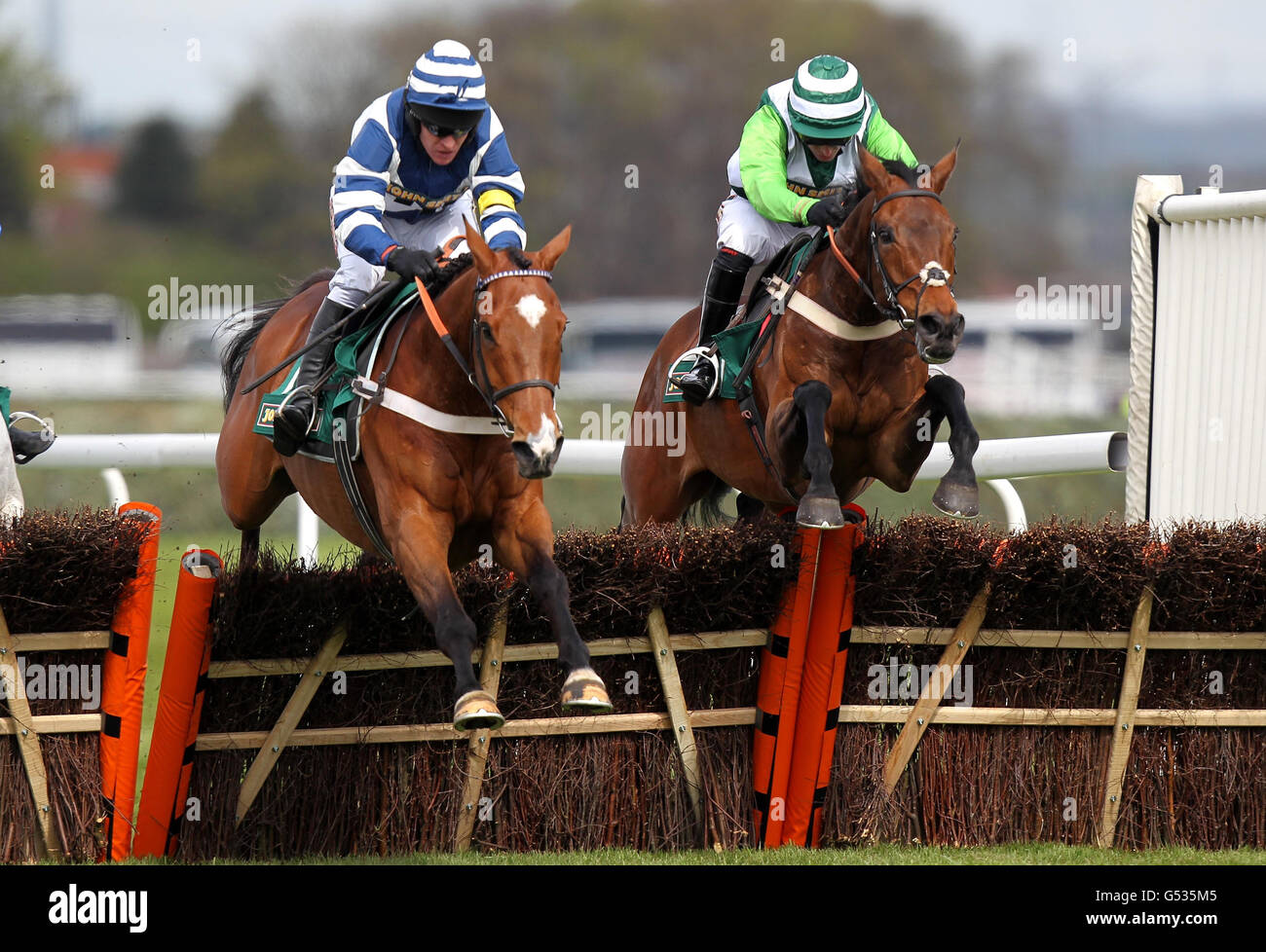 Eventual winner Oscar Whiskey ridden by Barry Geraghty (left) jumps the last from Rock on Ruby ridden by Noel Fehily (right) in the John Smith's Aintree Hurdle during day three of the 2012 John Smith's Grand National meeting at Aintree Racecourse, Liverpool. Stock Photo