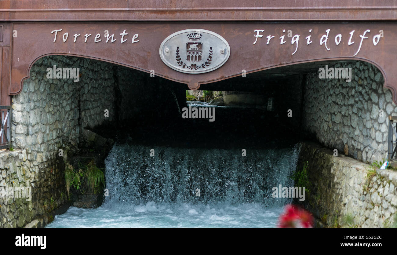 Frigidolfo River flows inside Ponte di Legno under a bridge Stock Photo