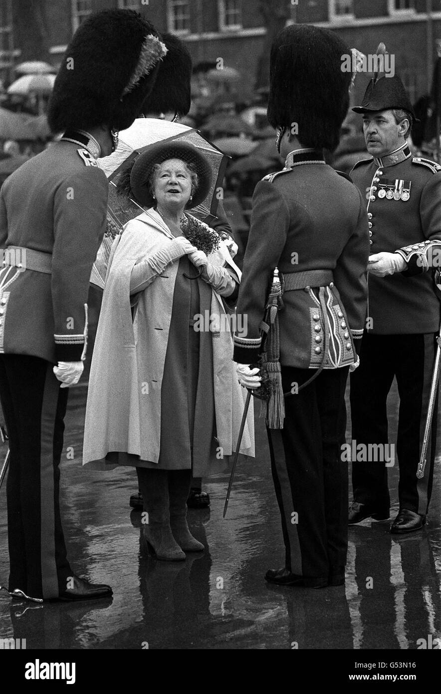 1980: An ample amount of shamrock adorns the Queen Mother's rain cape at Victoria barracks, Windsor, Berkshire, where she presented officers men of the Irish Guards with shamrock during their traditional St. Patrick's Day parade. Stock Photo