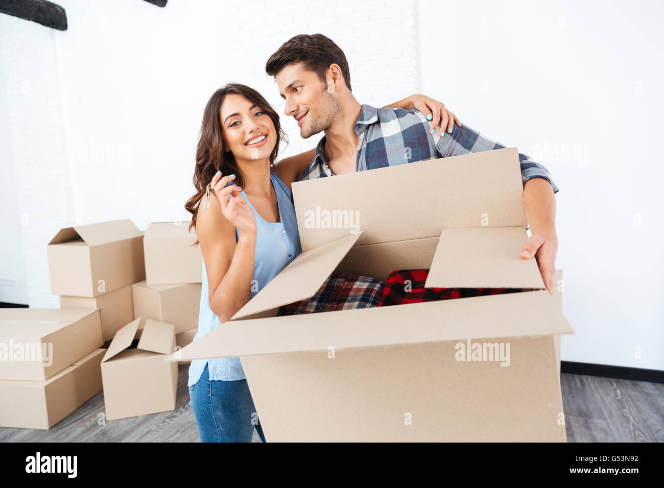 Happy young couple showing keys to new home and hugging Stock Photo - Alamy